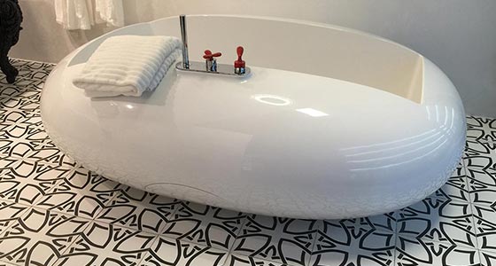Ei-förmige Badewanne in weiß mit passenden Fliesen als Boden