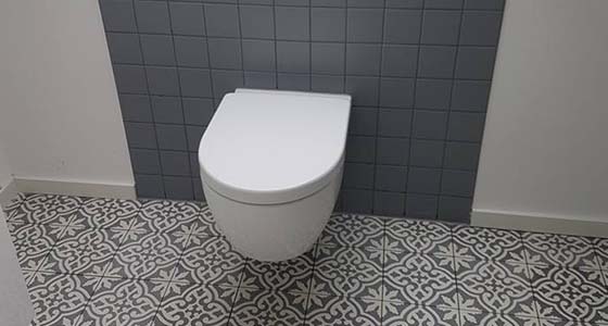 Toilette mit gefließter Rückwand